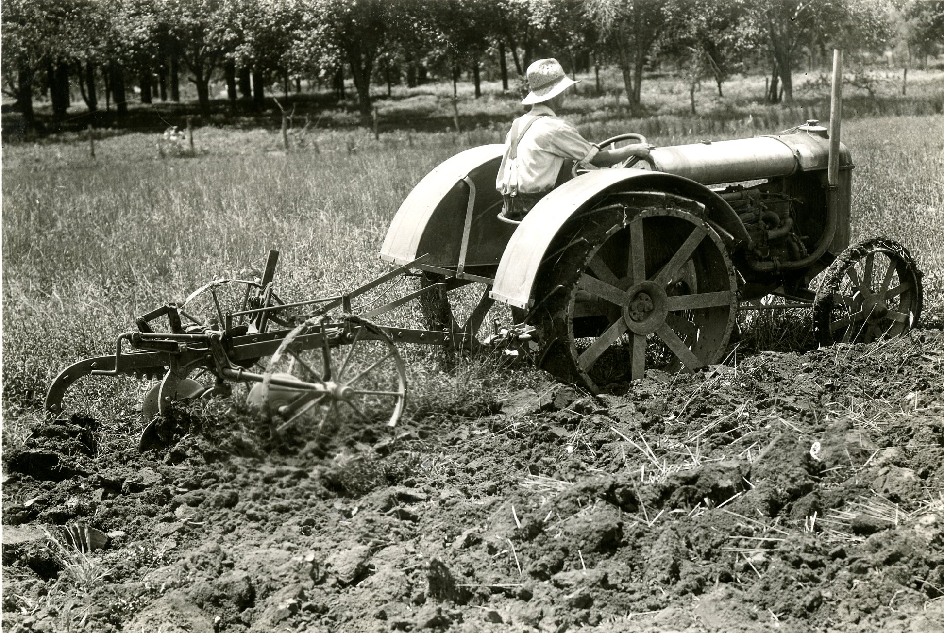 Farm worker riding on tractor